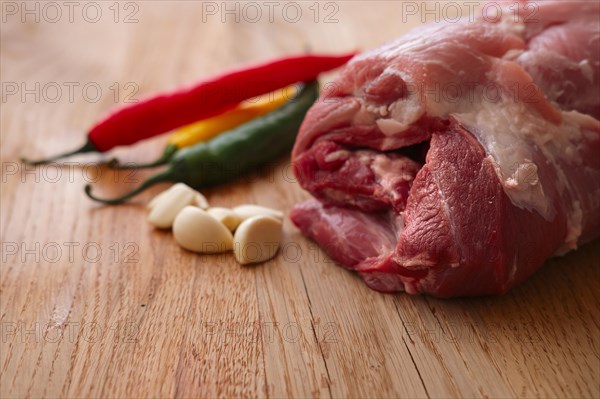 Fresh pork shoulder ready for baking with hot chilly and jalapeno pepper