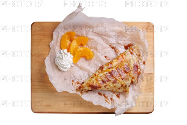 Thin pancakes stuffed with apricot and soft cheese isolated on white