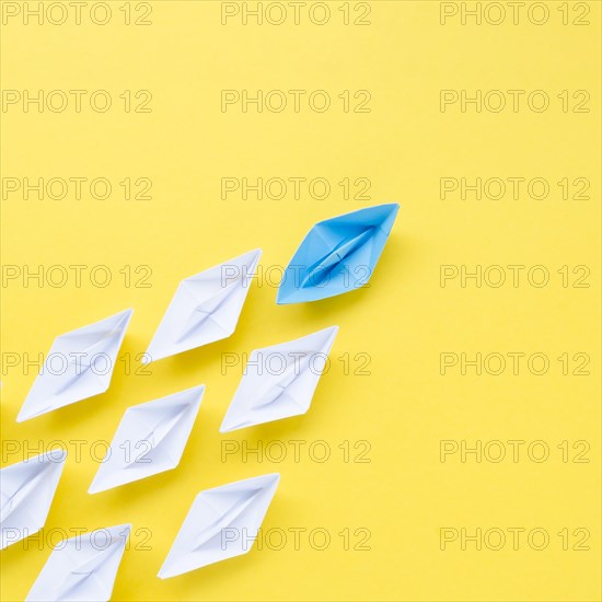 Composition individuality concept with paper boats yellow background