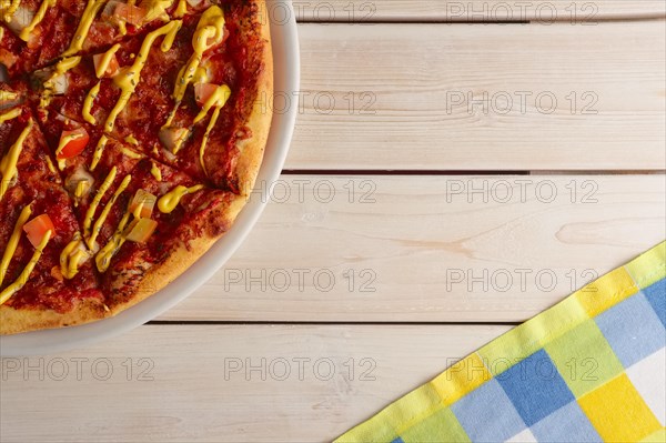 Top view of pizza with sun-dried tomatoes and mustard sauce
