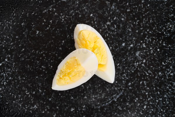 Top view of half of boiled egg cut on two pieces on a plate