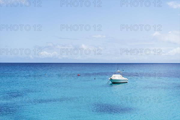 Small yacht on turquoise sea under blue sky in Punta Mujeres