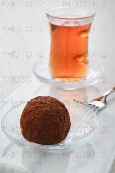Closeup view of chocolate biscuit dough cake and a cup of tea on a table