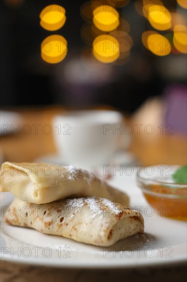 Soft focus photo of pancakes with jam and cup of coffee. Breakfast at a cafe