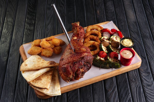 Fried turkey thigh with grilled vegetables and snack for beer