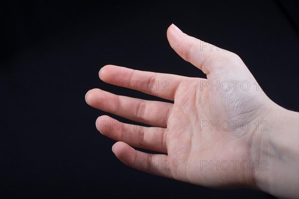 Five fingers of a child hand partly seen in black background