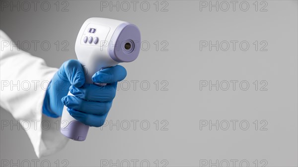 Doctor gloves holding thermometer with copy space