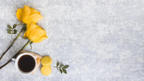 Rose flowers with macaroons coffee cup