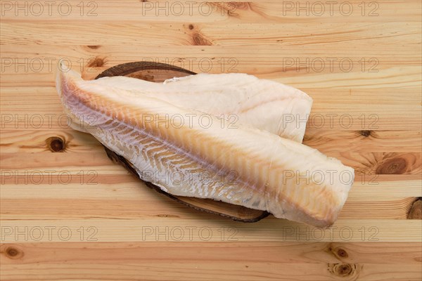 Frozen fillet of cod on wooden table