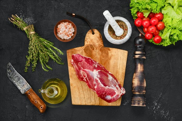 Overhead view of raw lamb rump on wooden cutting board