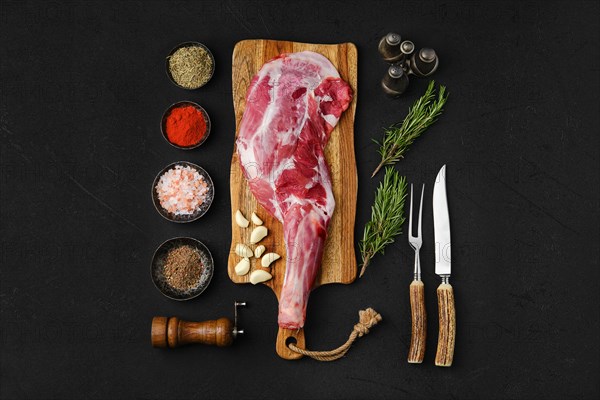 Raw peeled lamb shoulder ready for cooking on black background