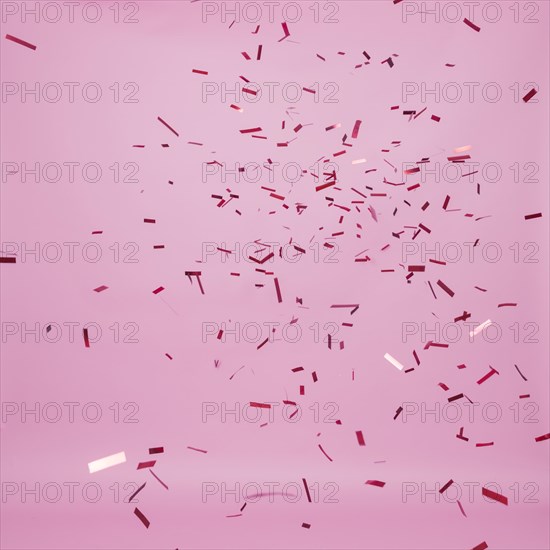 Dark confetti falling pink background