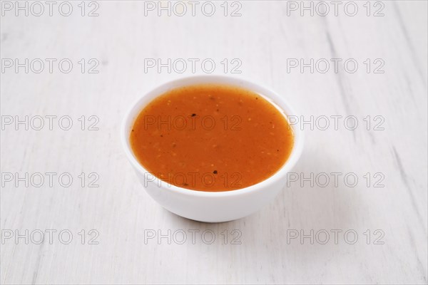 Small bowl with spicy orange sauce for poultry