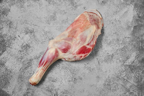 Raw lamb shoulder chump on on shabby grey background