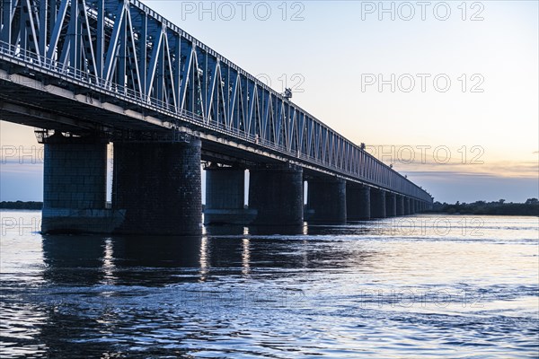 Giant bridge spanning over the Amur river at sunset