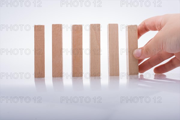 Hand holding wooden domino on a white background