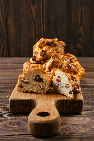 Closeup view of cookies with raisins on wooden cutting board