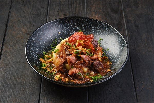 Beef goulash with bacon and mashed potato on a table