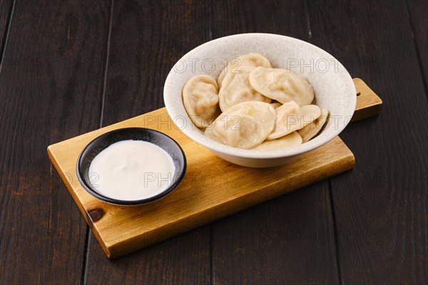 Traditional dumplings with pork farce served with sour cream