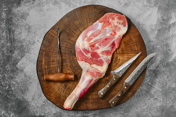 Raw fresh lamb shoulder chump on butcher's cutting log