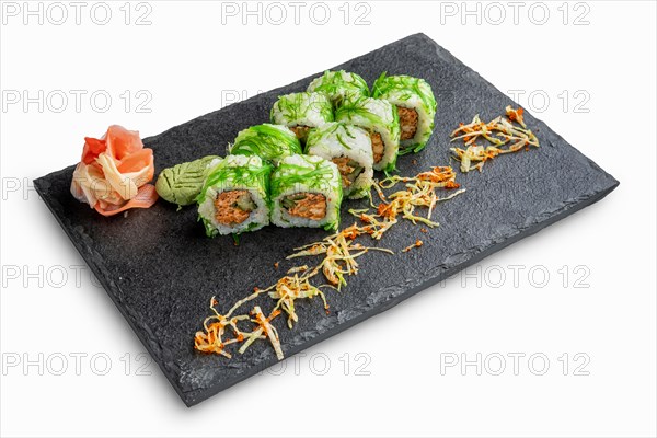 Set of rolls with wasabi and pickled ginger on stone serving board isolated on white