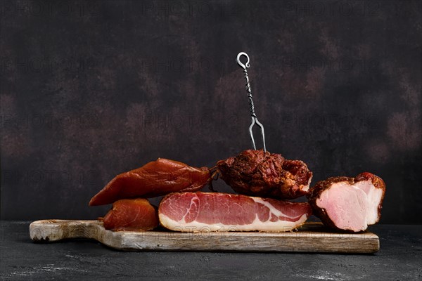 Wooden cutting board with assortment of pork ham