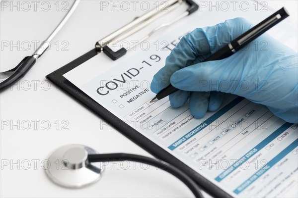 Close up doctor completing covid medical form