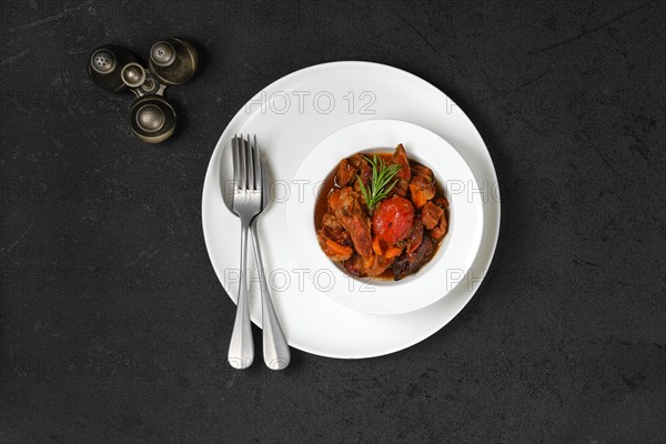 Overhead view of lamb stew with tomato on a plate