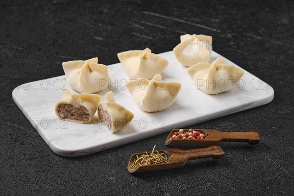 Homemade spicy beef dumplings on marble serving plate