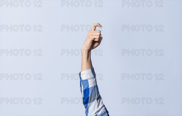 Hand gesturing the letter X in sign language on an isolated background. Man's hand gesturing the letter X of the alphabet isolated. Letter X of the alphabet in sign language