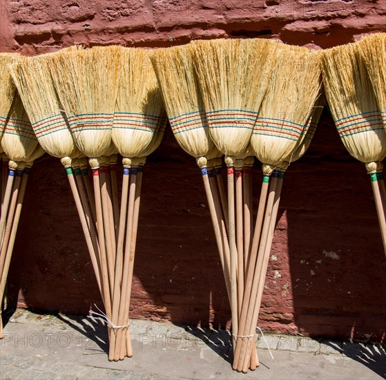 Set of yellow straw broom in a bazaar