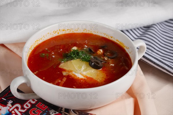 Russian traditional solyanka soup. Authentic soup saltwort in ceramic plate