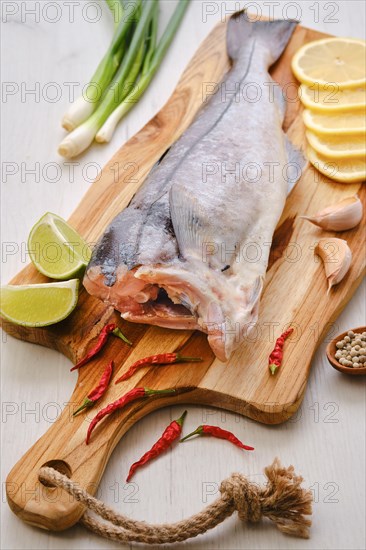 Raw fresh haddock carcass on wooden cutting board