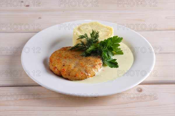 Fish cutlet with mashed potato on wooden table