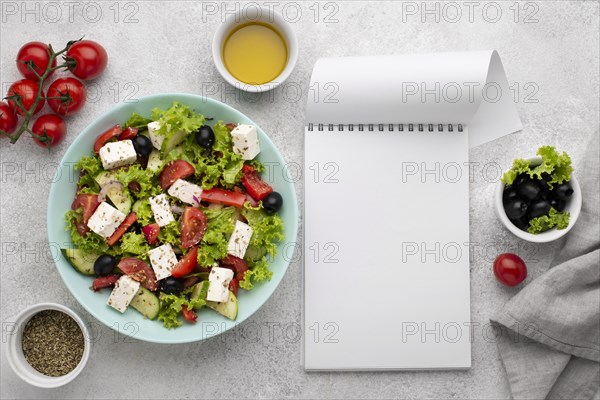Top view salad with feta cheese tomatoes and olives with blank notepad. Resolution and high quality beautiful photo