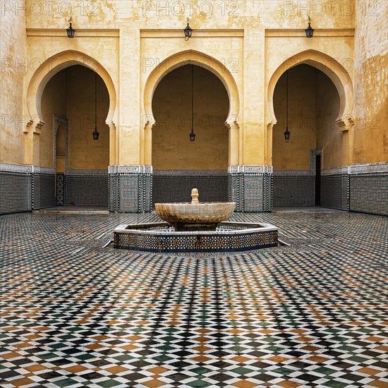 Fountain in front of arcades in the courtyard