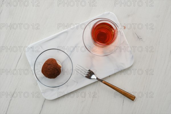Top view of chocolate biscuit dough cake and a cup of tea on a table