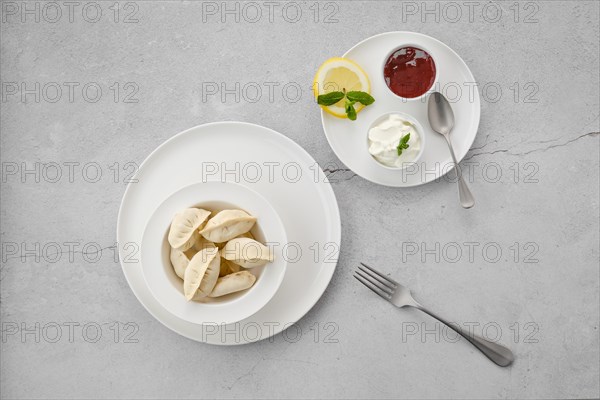 Frozen semifinished vareniki stuffed with strawberry on grey background