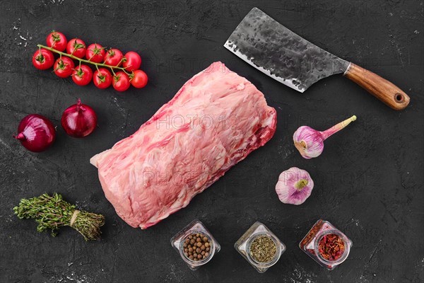 Raw fresh pork collar joint meat on black background with spice