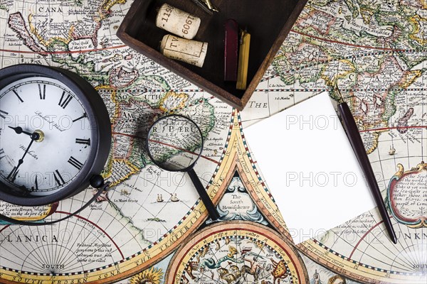 Elevated view clock magnifying glass colorful ancient map