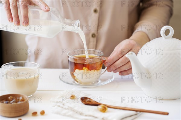 Front view person preparing milk tea