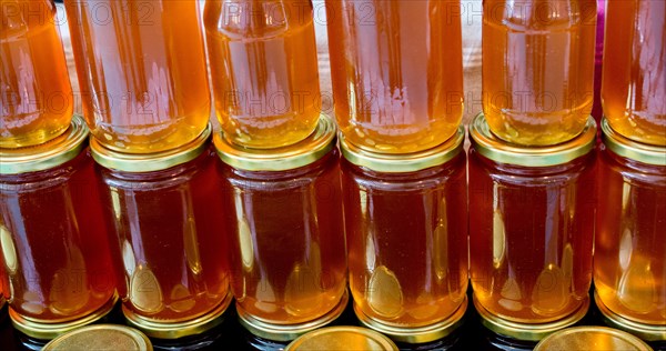 Glass jar of full of fresh honey with lid