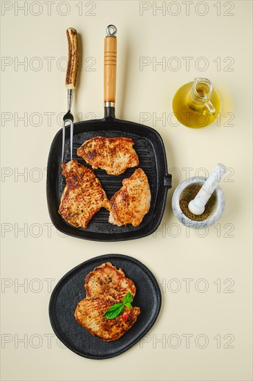 Overhead view of fried chopped pork tenderloin on plate and pan