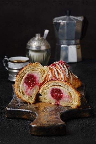 Fresh croissant cut on half showing raspberry stuffing