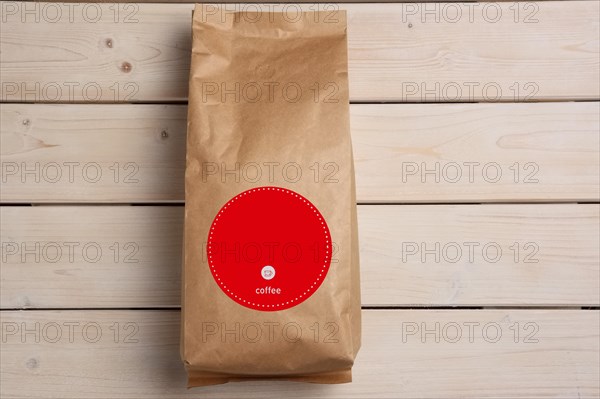 Big coffee paper pack on wooden table. Top view