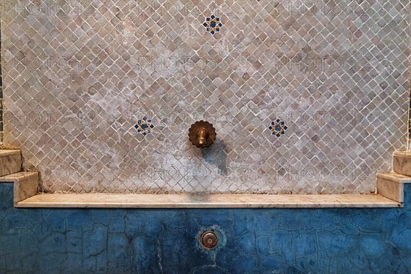 Ornate tap in tiled wall