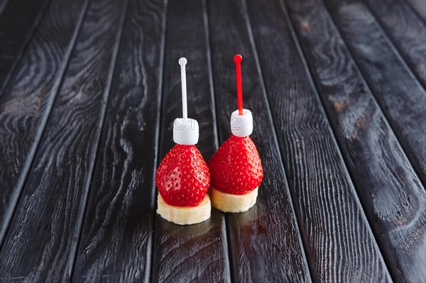 Appetizer for reception. Fresh banana with strawberry and small marshmallows on skewer