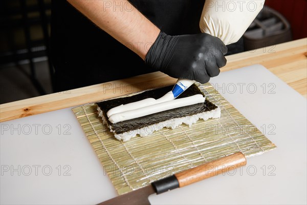 Hands of chef making salmon rolls