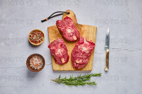 Overhead view of raw fresh deer neck with spice and herb over concrete background