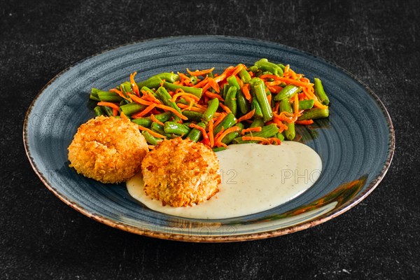 Meatballs in breading served with green bean and spicy carrot
